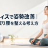 明るいスタジオのマットの上で背筋をすっと伸ばして座る女性の実写写真