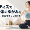 明るいスタジオでマットに座り骨盤に手を当てて姿勢を整える女性の実写写真