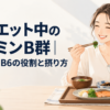 主食・主菜・副菜がそろった和定食を前に笑顔で箸を取る女性